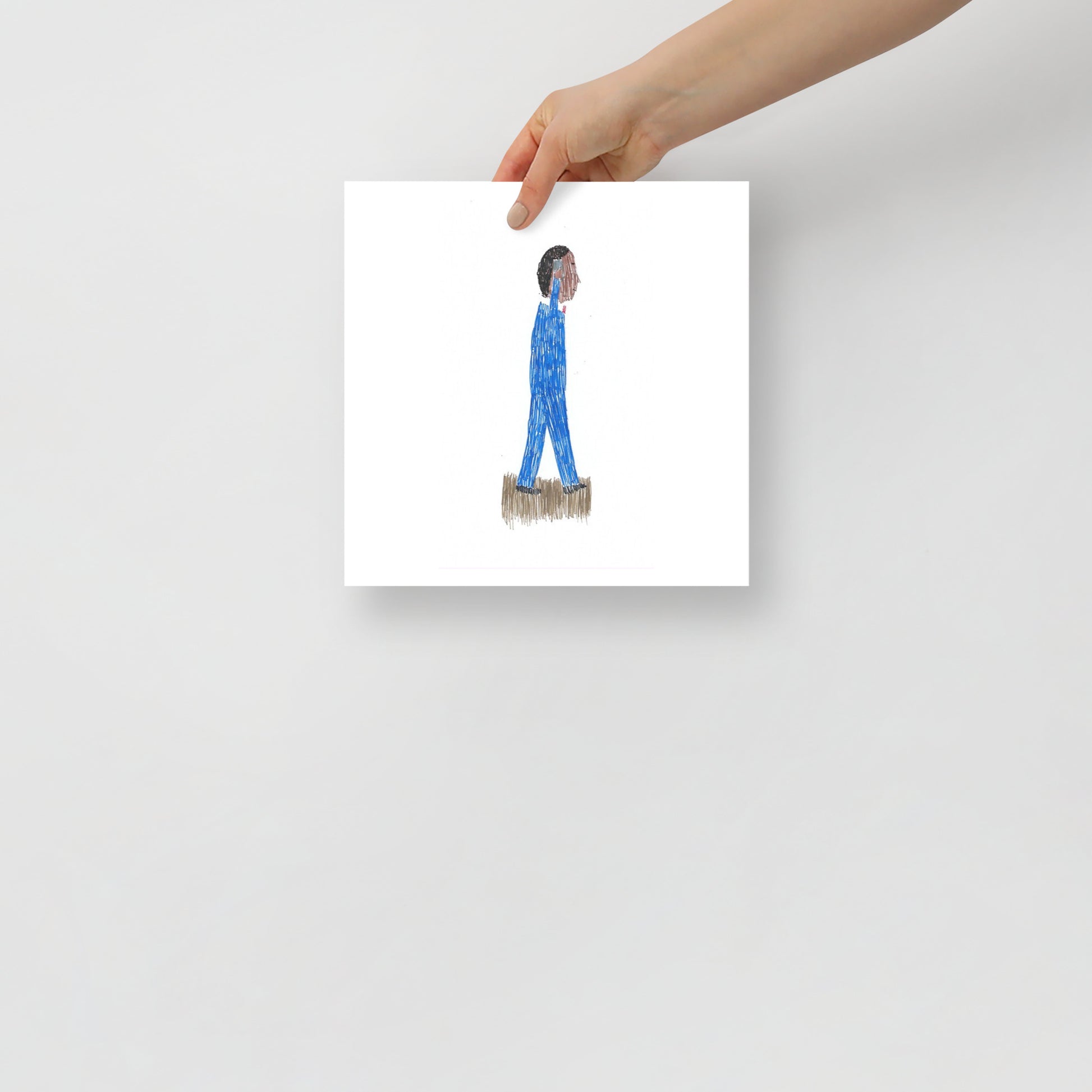 This image shows an art print of a square artwork featuring a figure in blue attire with textured hair, using a mobile phone,walking on a soft, grassy patch against a plain white background.